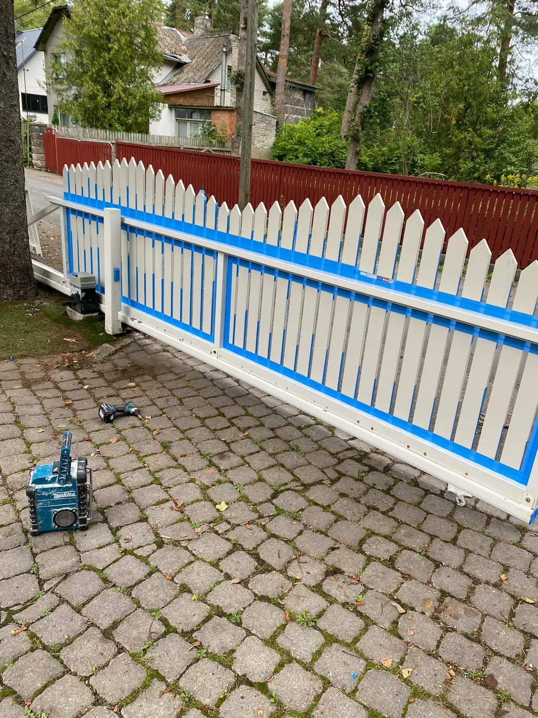 Autovärava metallraam värvimistööde ajal, puitosad kaitstud maalriteibiga