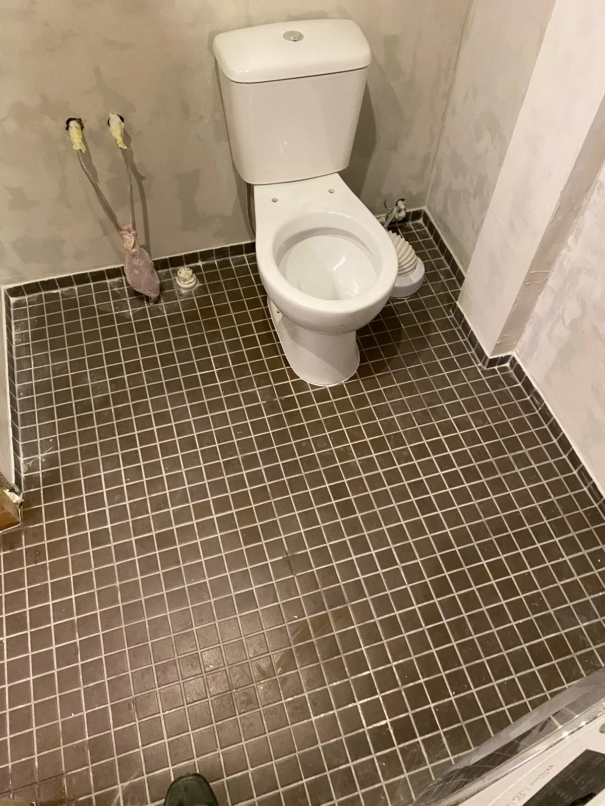 Plaaditud põrand ja paigaldatud WC-pott enne seinaviimistluse lõpetamist